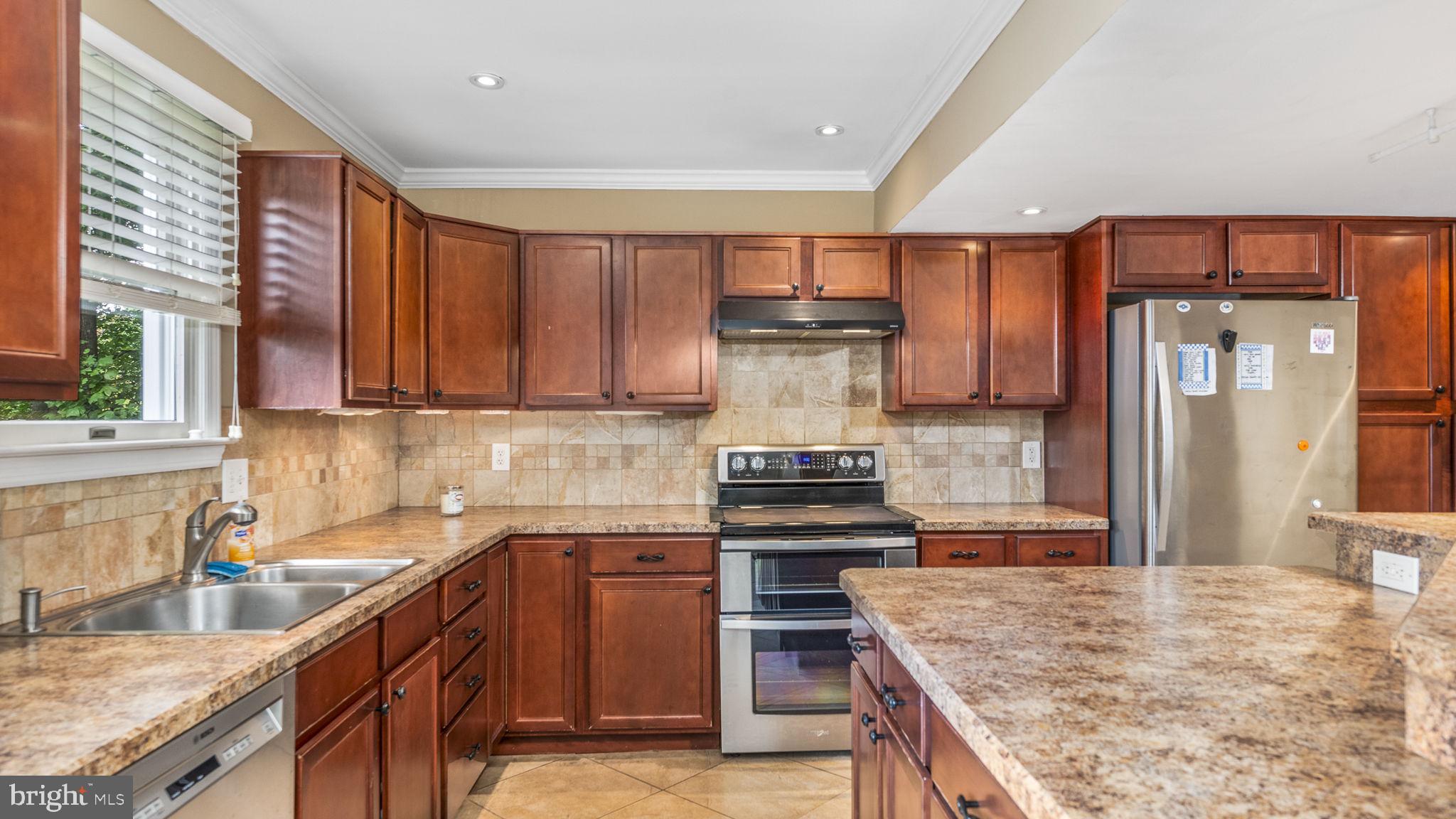 a kitchen with kitchen island granite countertop a sink stove and cabinets