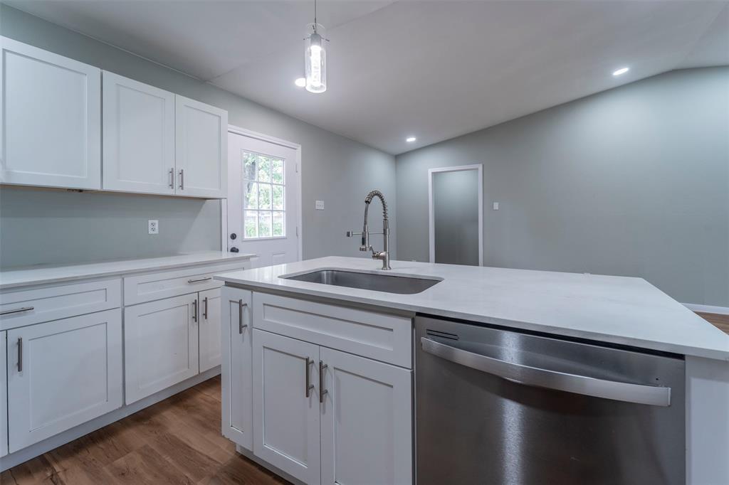 a kitchen with a sink cabinets and wooden floor