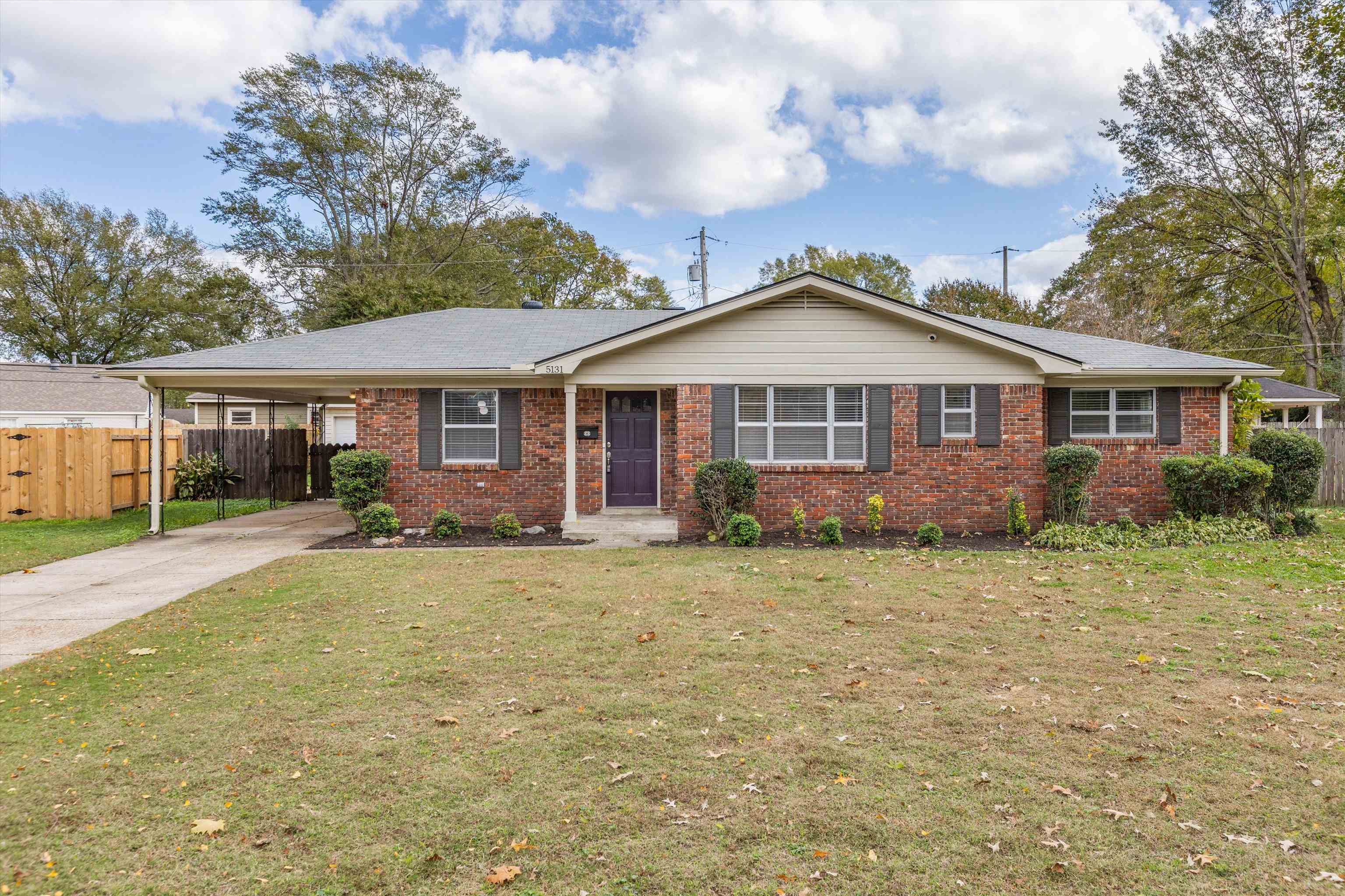 Ranch-style house with a carport and a front lawn