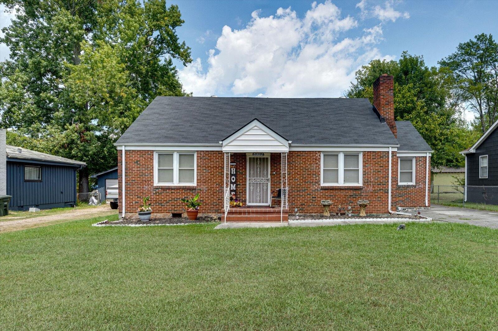 a front view of a house with a yard and trees