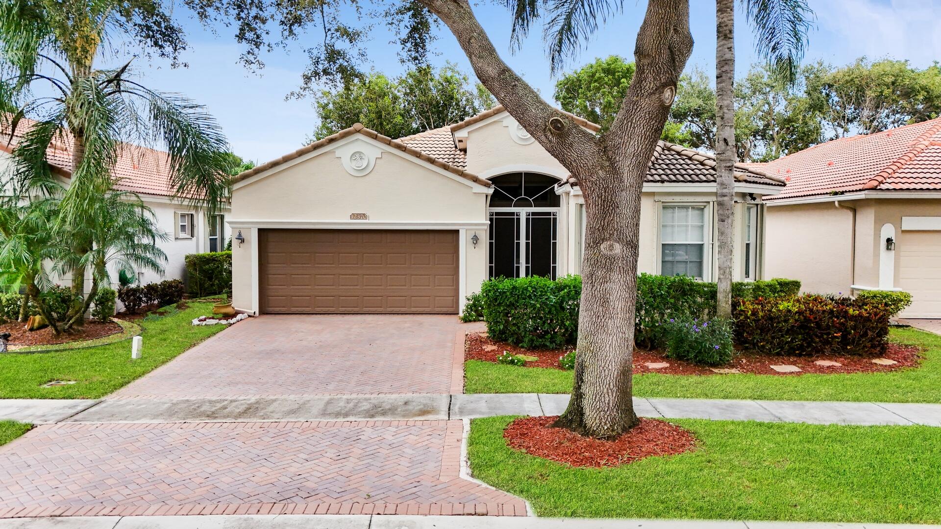 a front view of a house with a yard and shrubs