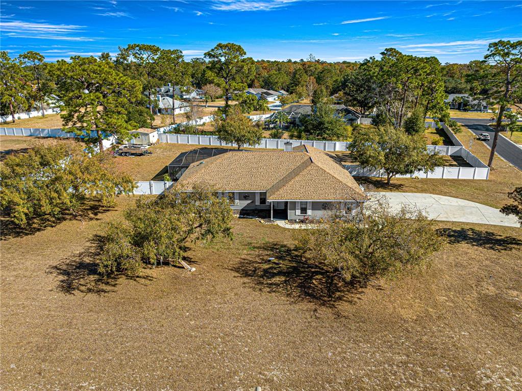 an aerial view of residential houses with outdoor space and trees