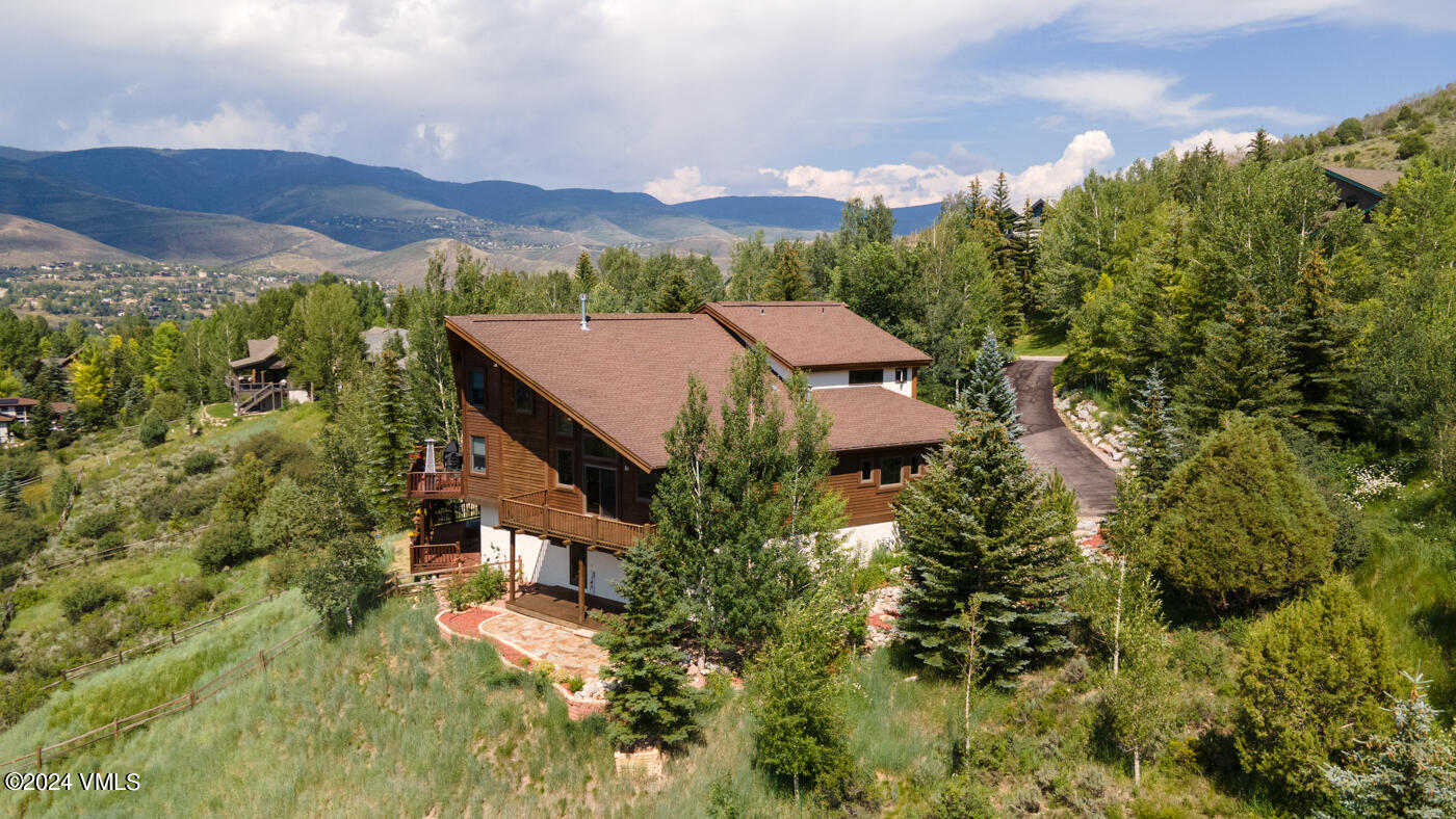 a aerial view of a house with a yard and mountain view