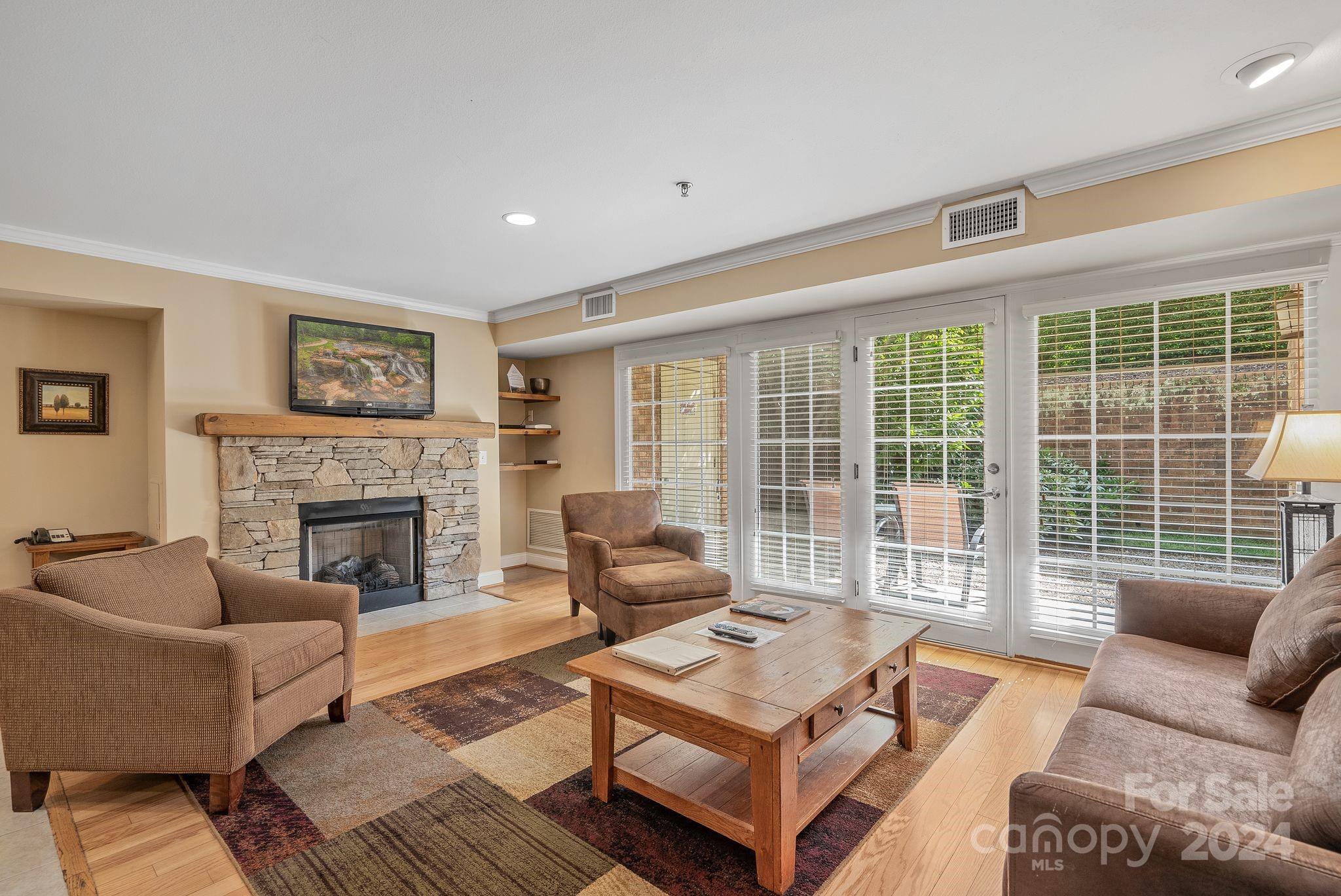 a living room with furniture a fireplace and a large window