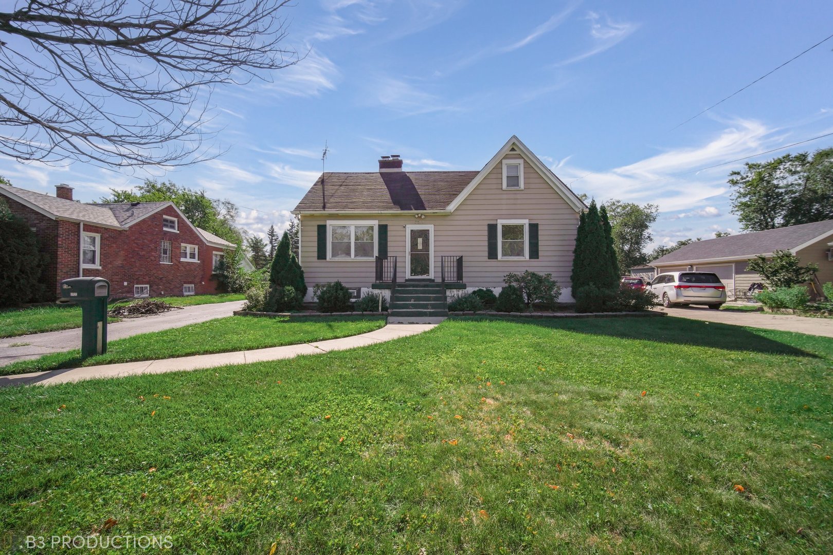 a front view of a house with a garden and trees