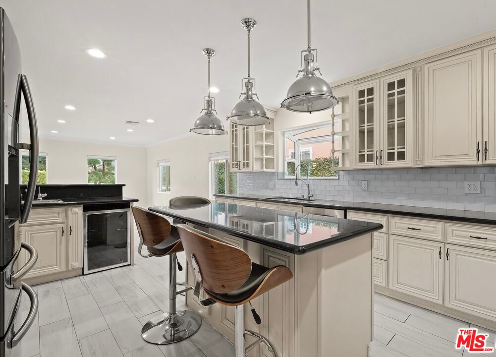 a kitchen with kitchen island granite countertop a sink a counter top space appliances and cabinets