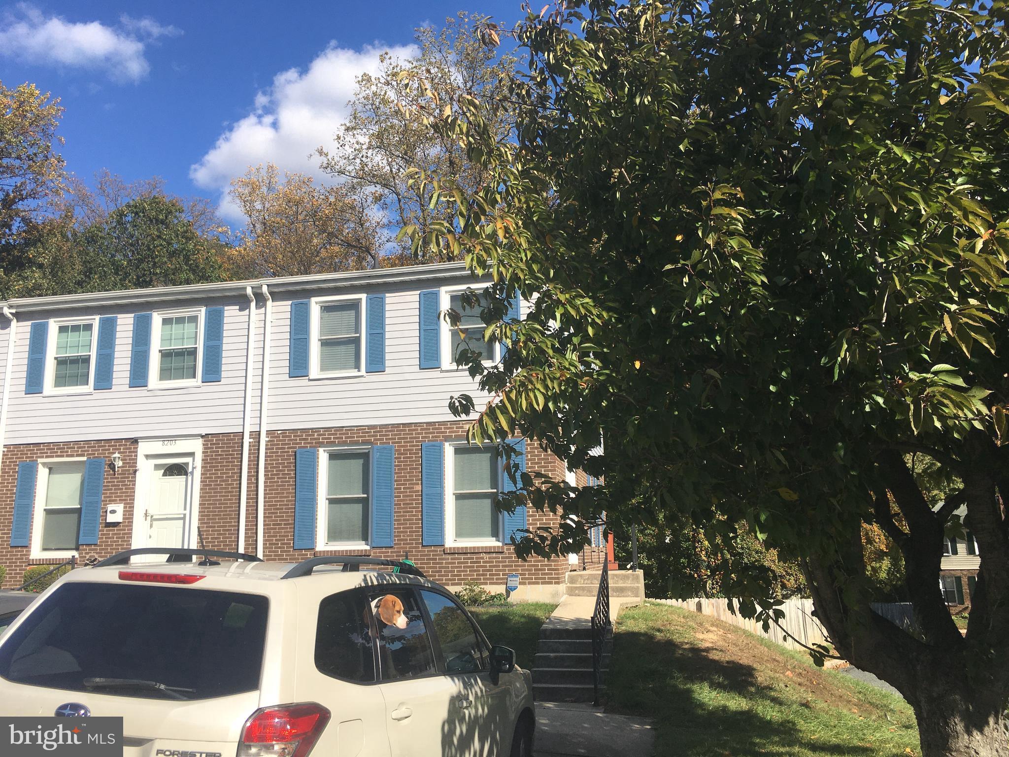 a front view of a house with yard and trees