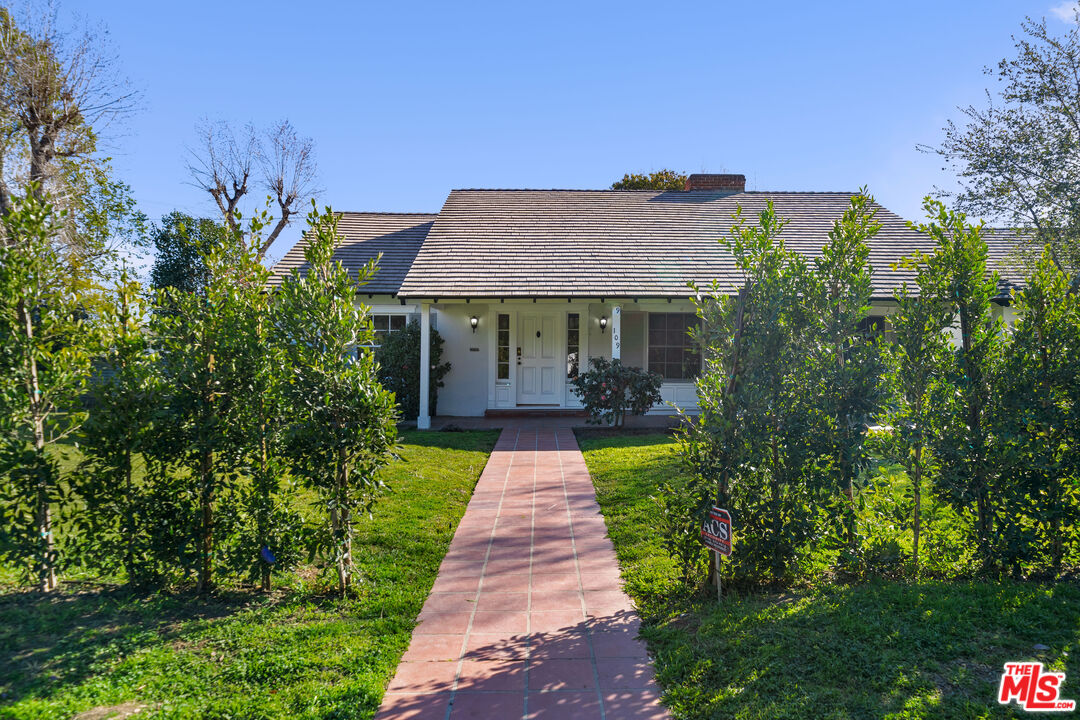 a front view of a house with yard and green space