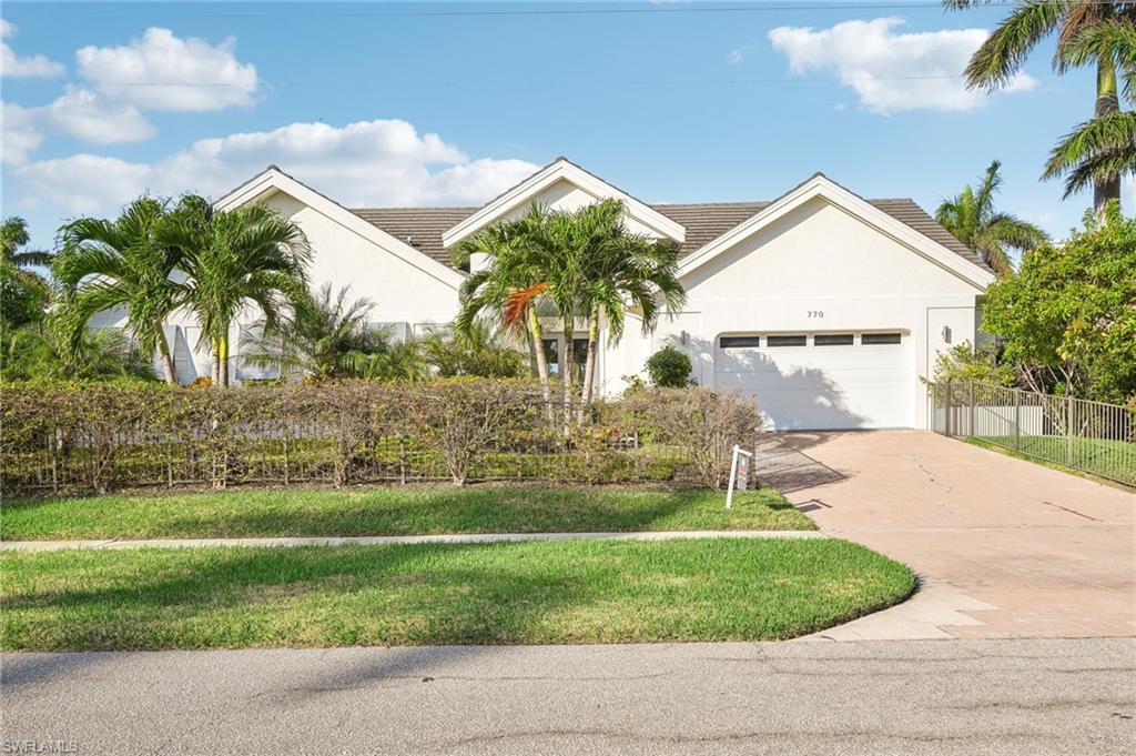 View of front of property featuring a front yard and a garage