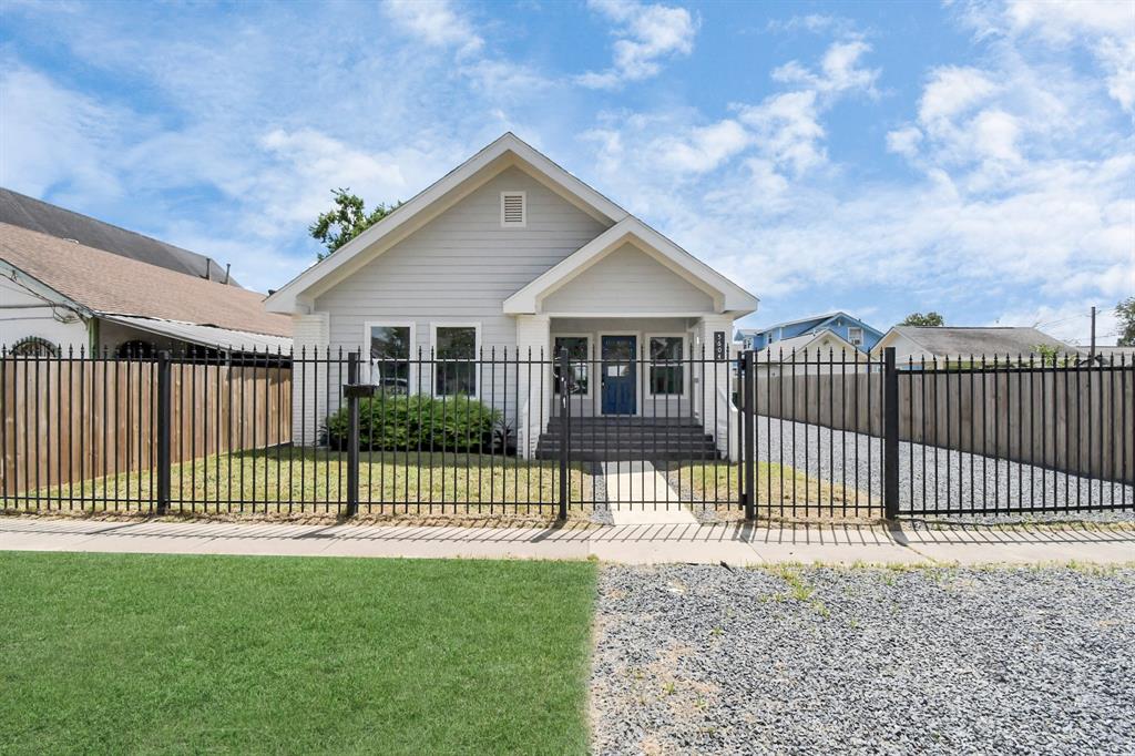 a view of a house with a small yard and wooden fence