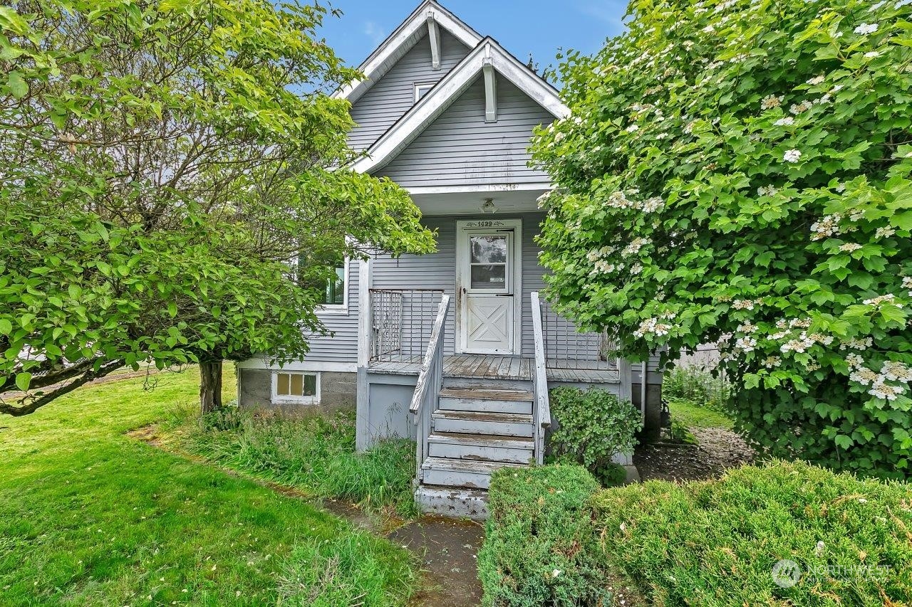 a front view of a house with a yard and trees