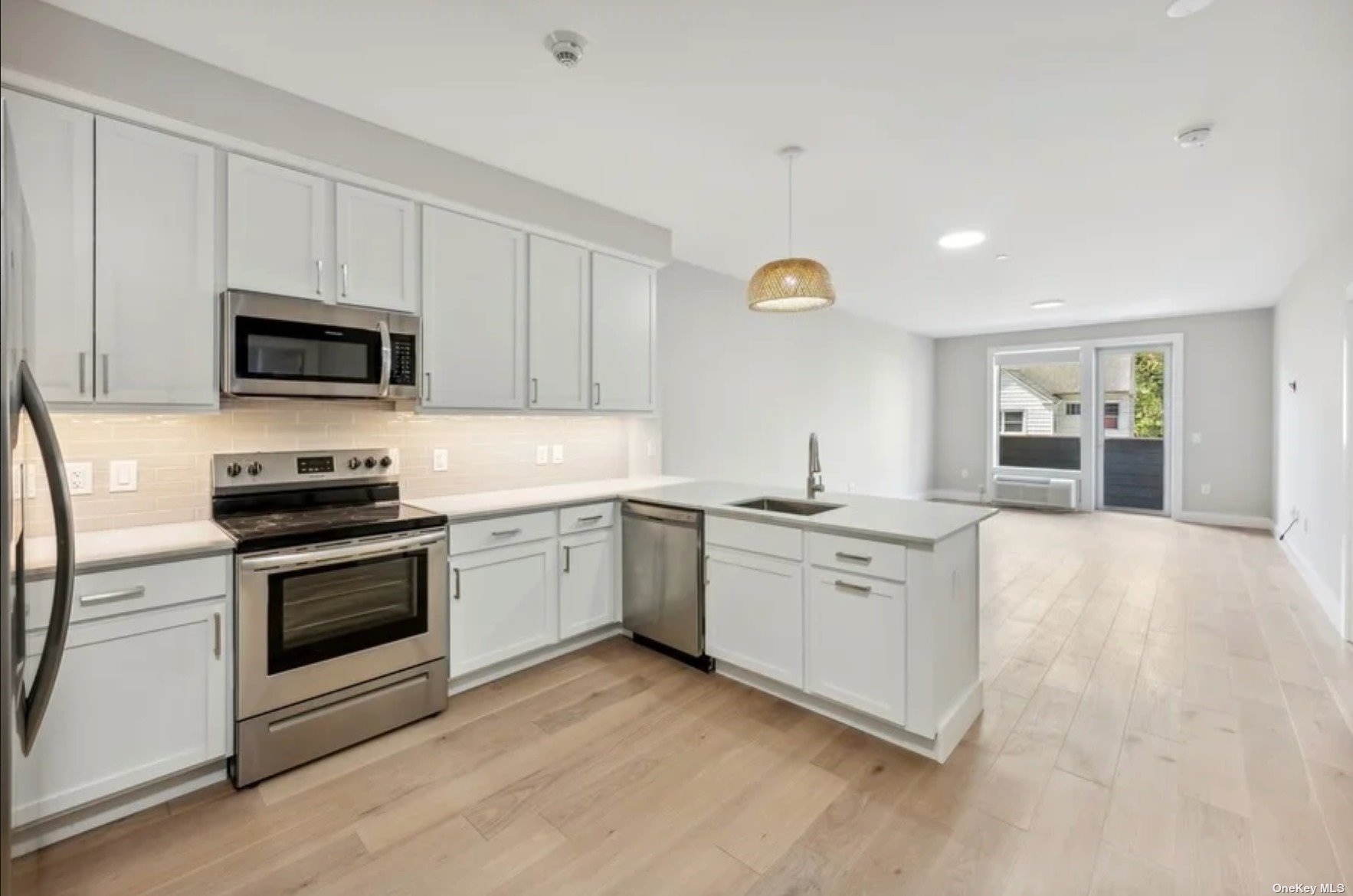 a kitchen with granite countertop white cabinets and stainless steel appliances