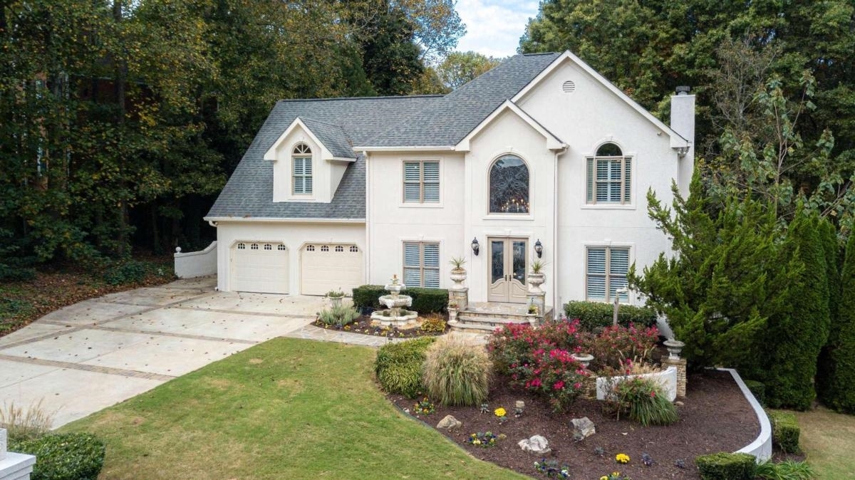 a view of a white house with a yard and sitting area