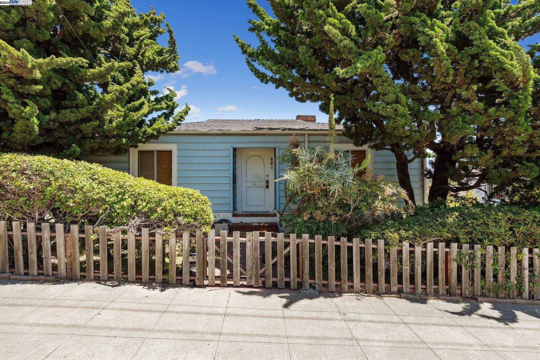 a view of a house with a small yard and wooden fence