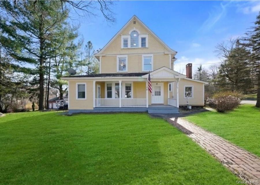 a front view of a house with a garden and trees