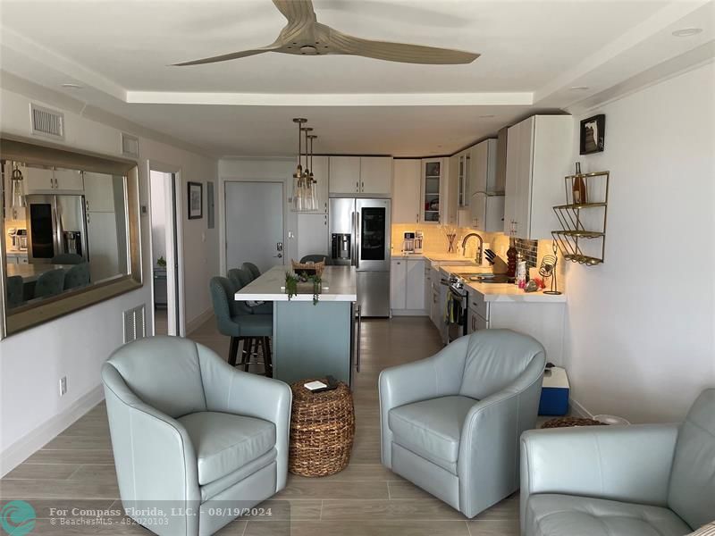 a living room with furniture and a view of kitchen