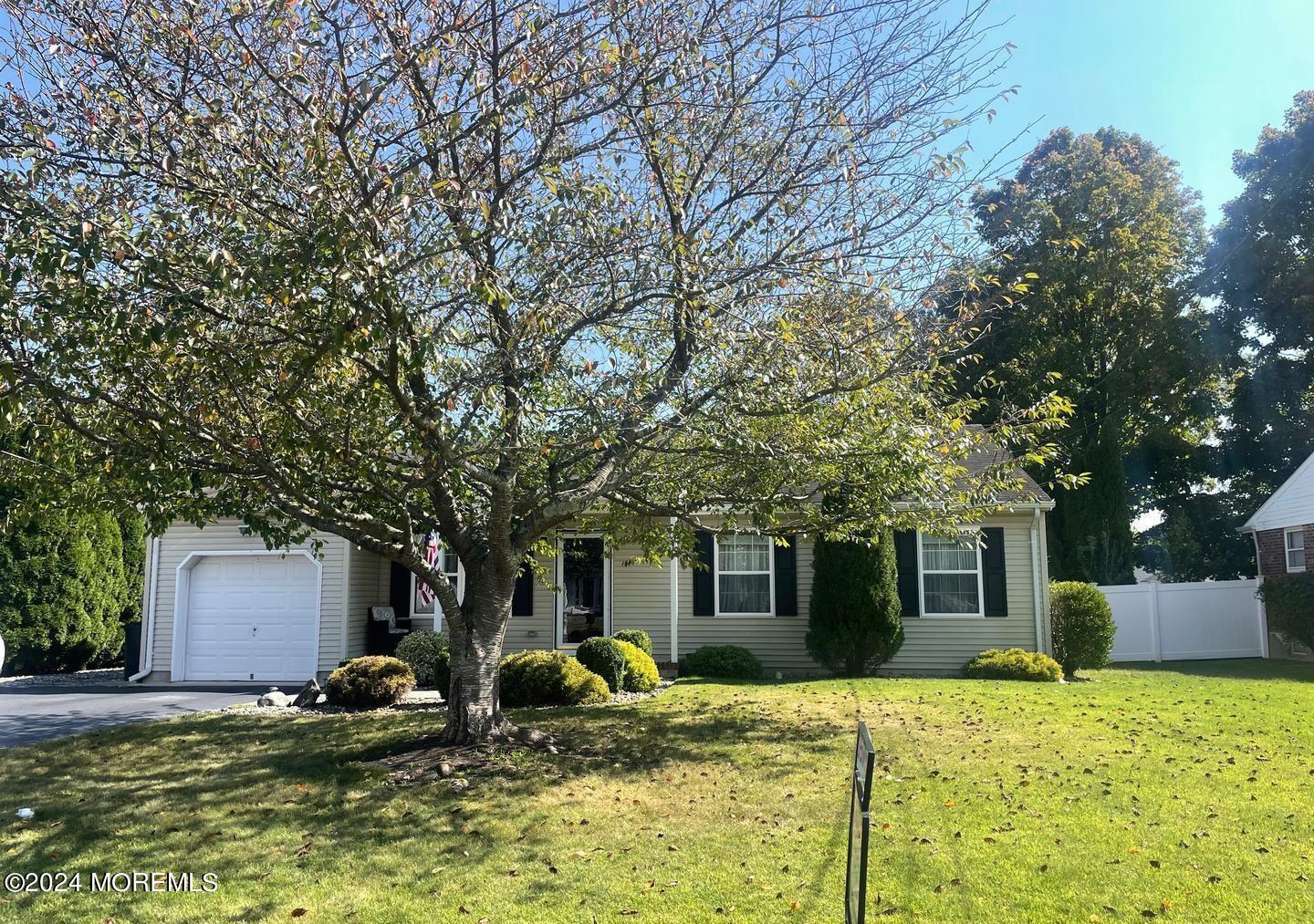 a view of a house with backyard and trees