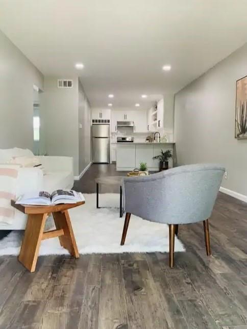 a living room with stainless steel appliances kitchen island furniture and a table