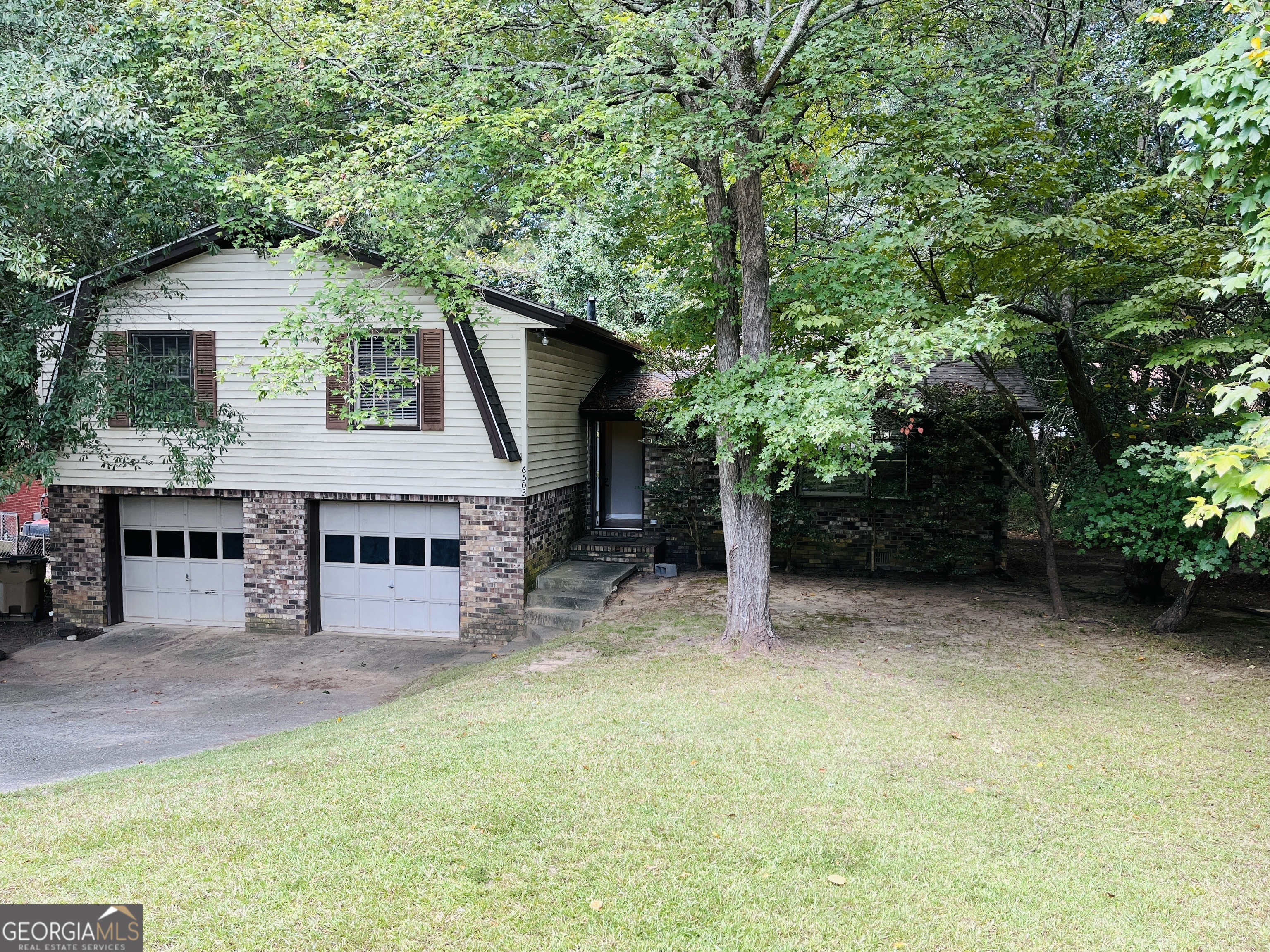 a view of house with outdoor seating and green space