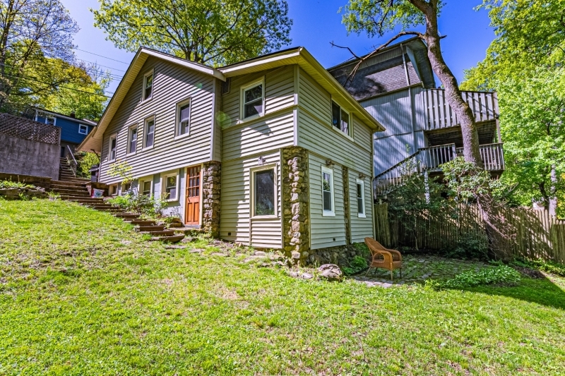 a front view of a house with a garden and plants