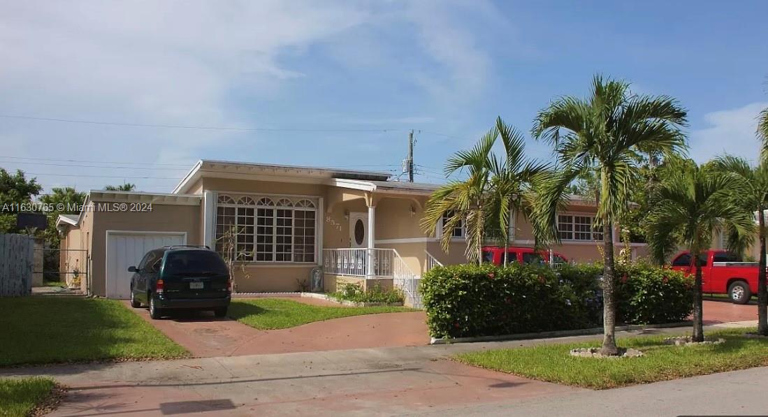 a front view of a house with a garden and plants