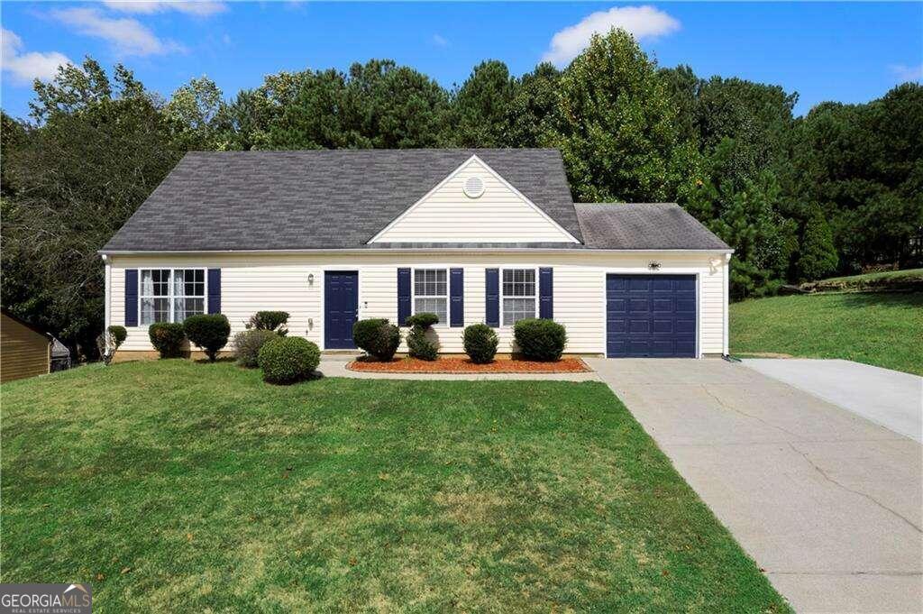 a front view of a house with a yard fire pit and trees in the background