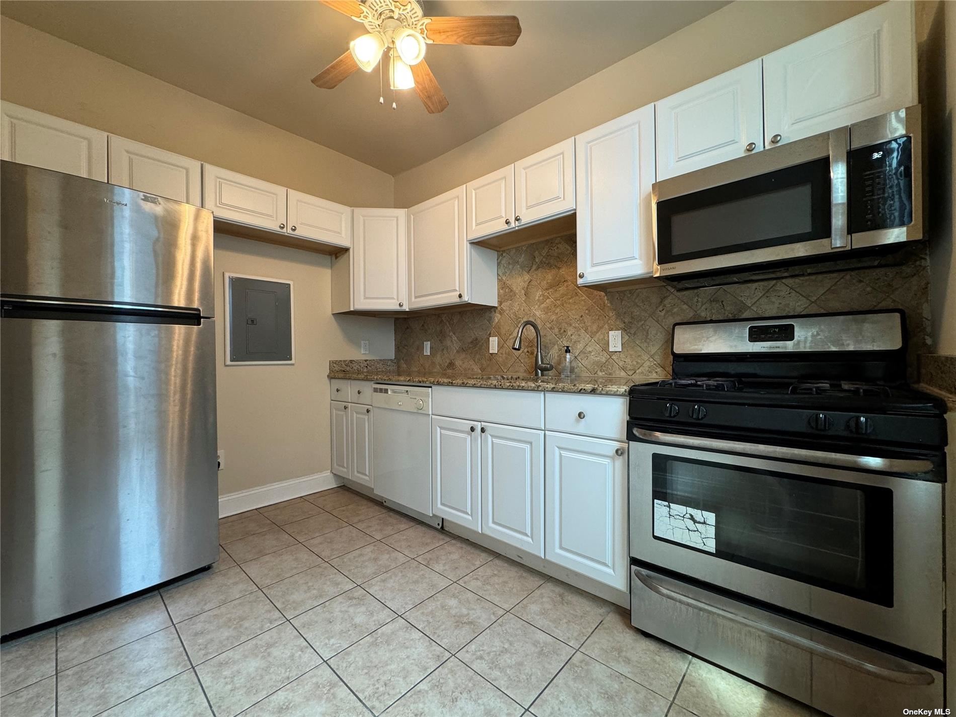 a kitchen with stainless steel appliances granite countertop a refrigerator stove and microwave