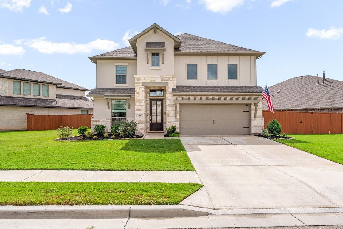 a front view of a house with a yard and garage