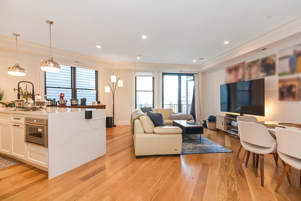 a living room with kitchen island furniture and a flat screen tv