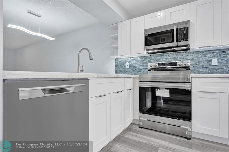 a kitchen with granite countertop a stove and a microwave