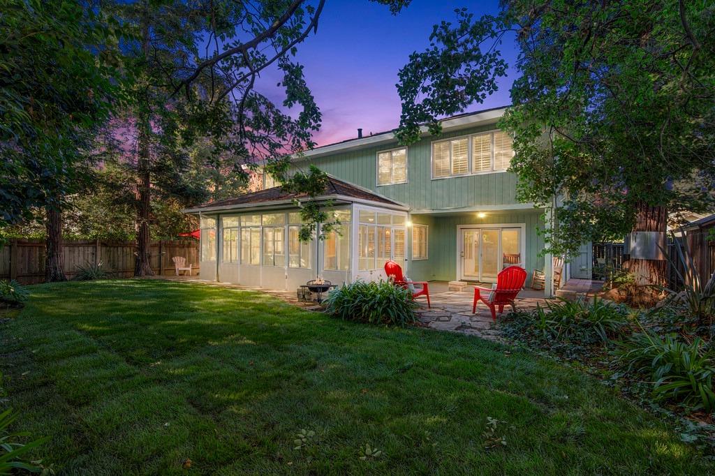 a view of a house with a backyard and a tree