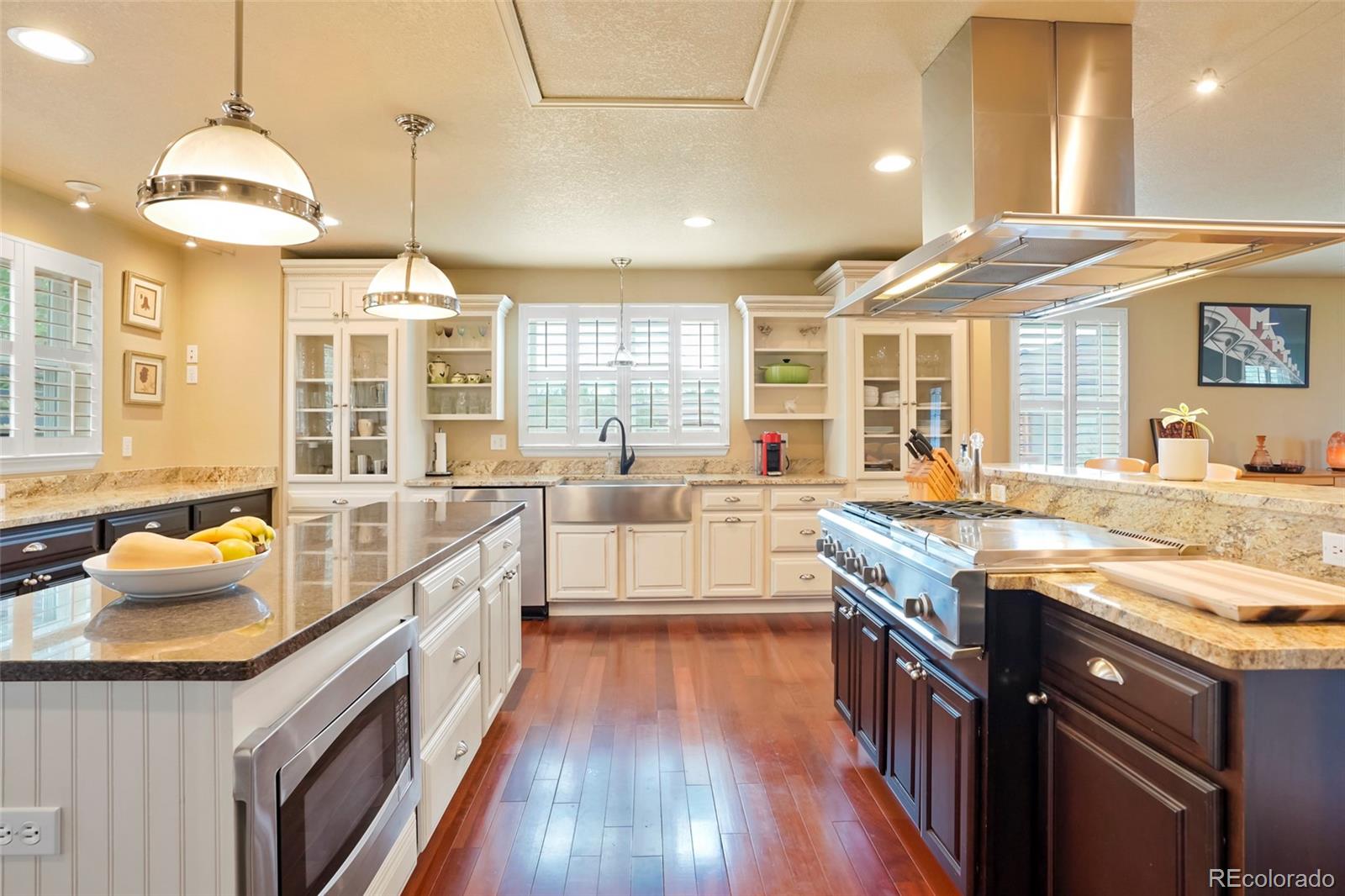 a large kitchen with stainless steel appliances granite countertop a lot of counter space and wooden floors