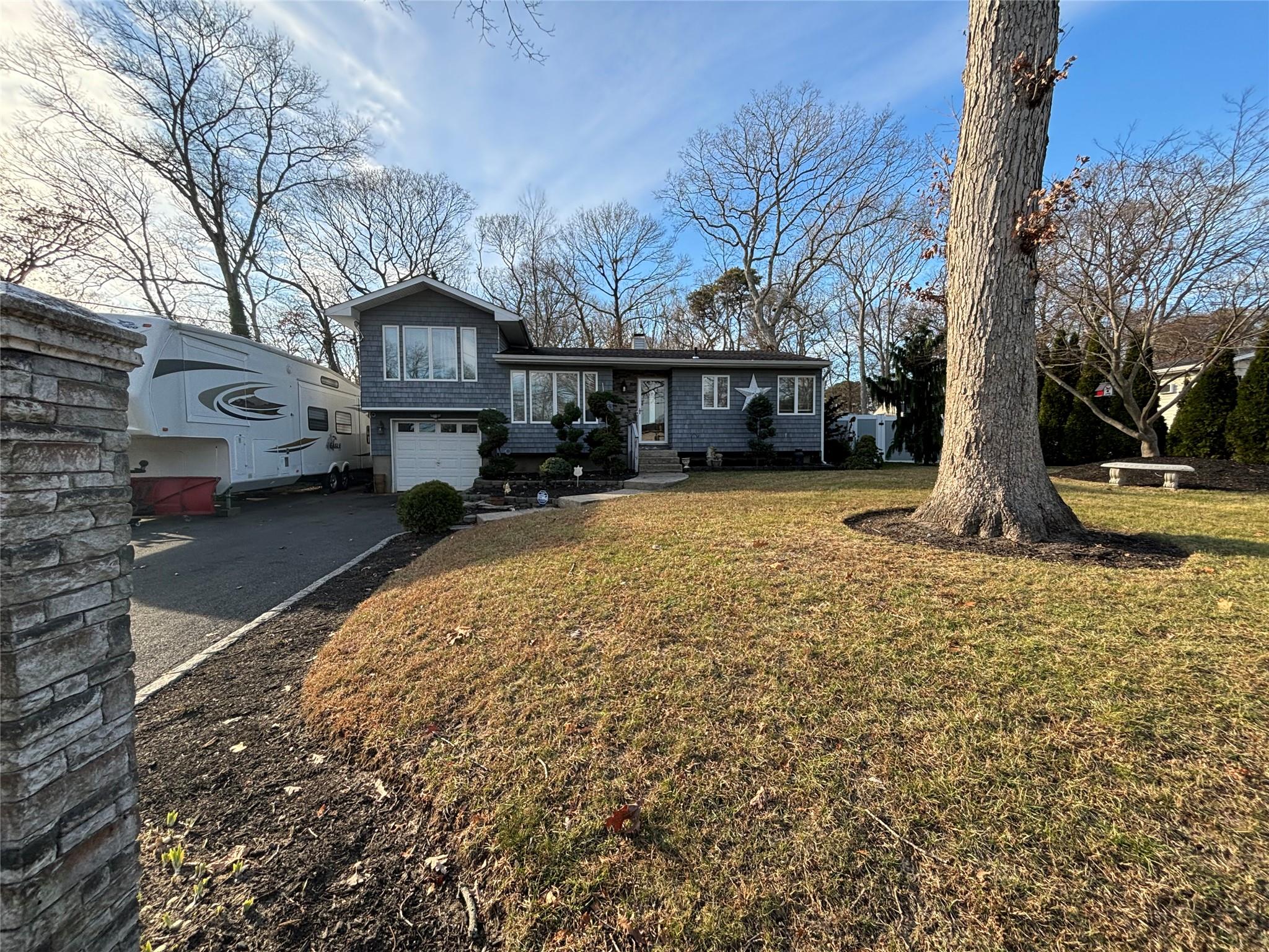 Split level home featuring a front yard and a garage