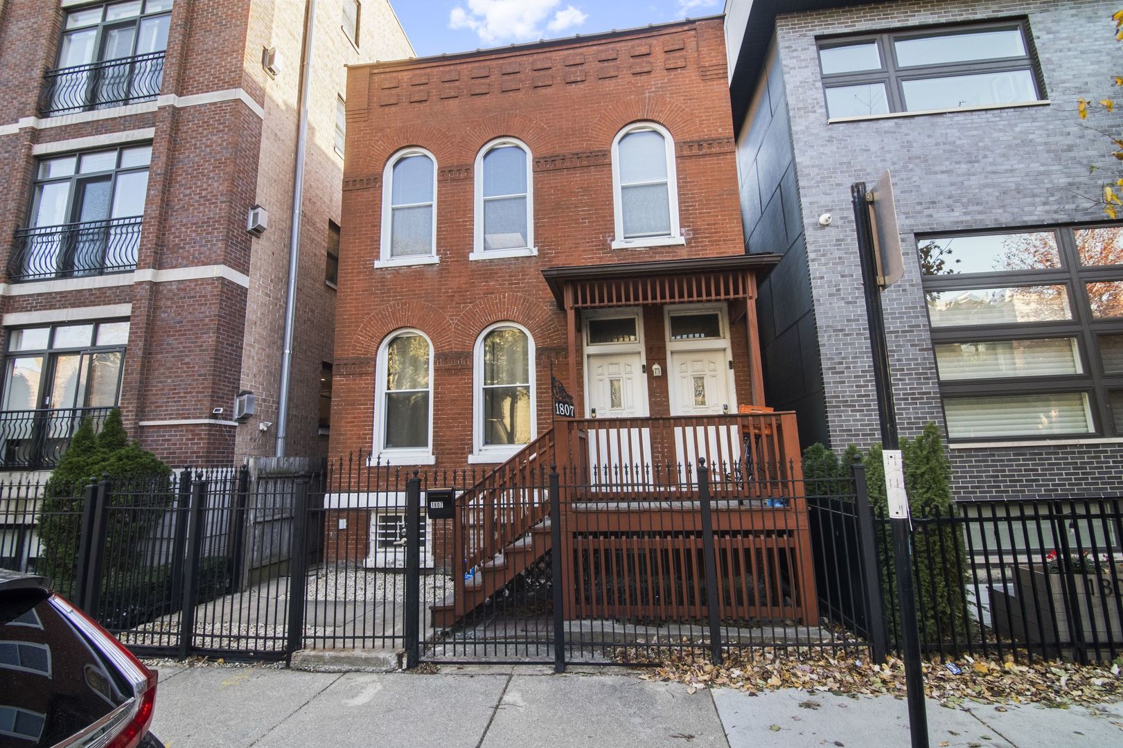 a front view of a house with iron fence