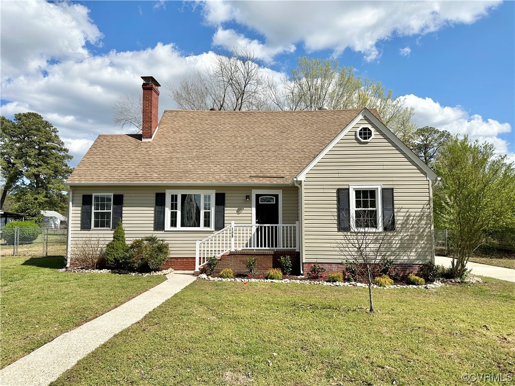 a front view of house with yard and trees in the background