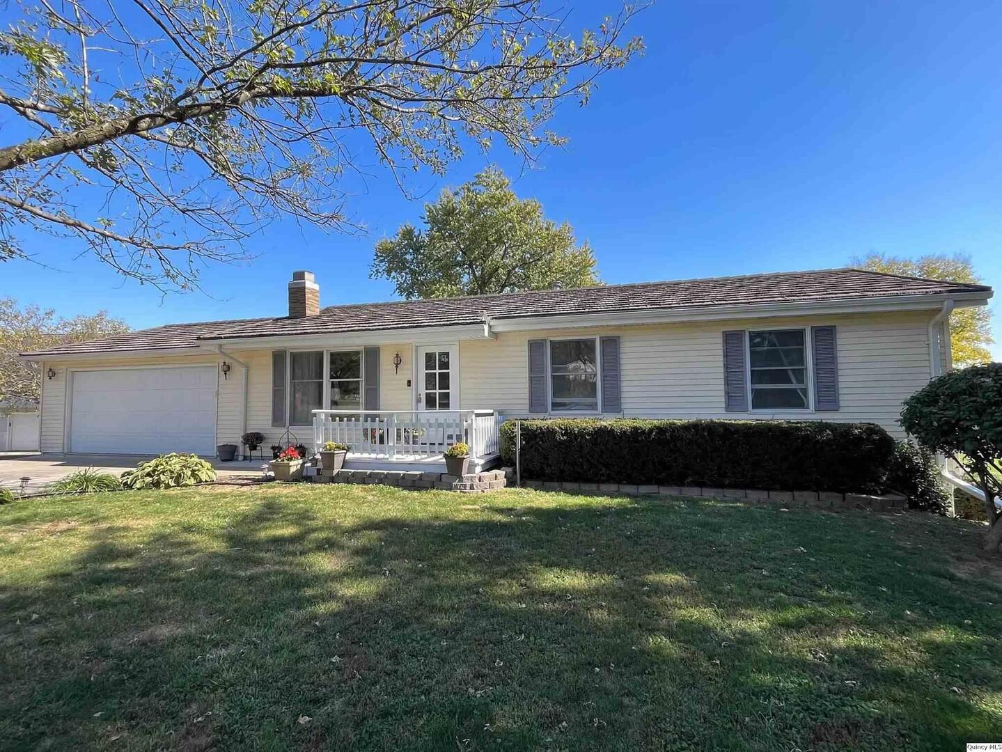 a view of a house with a patio and a yard