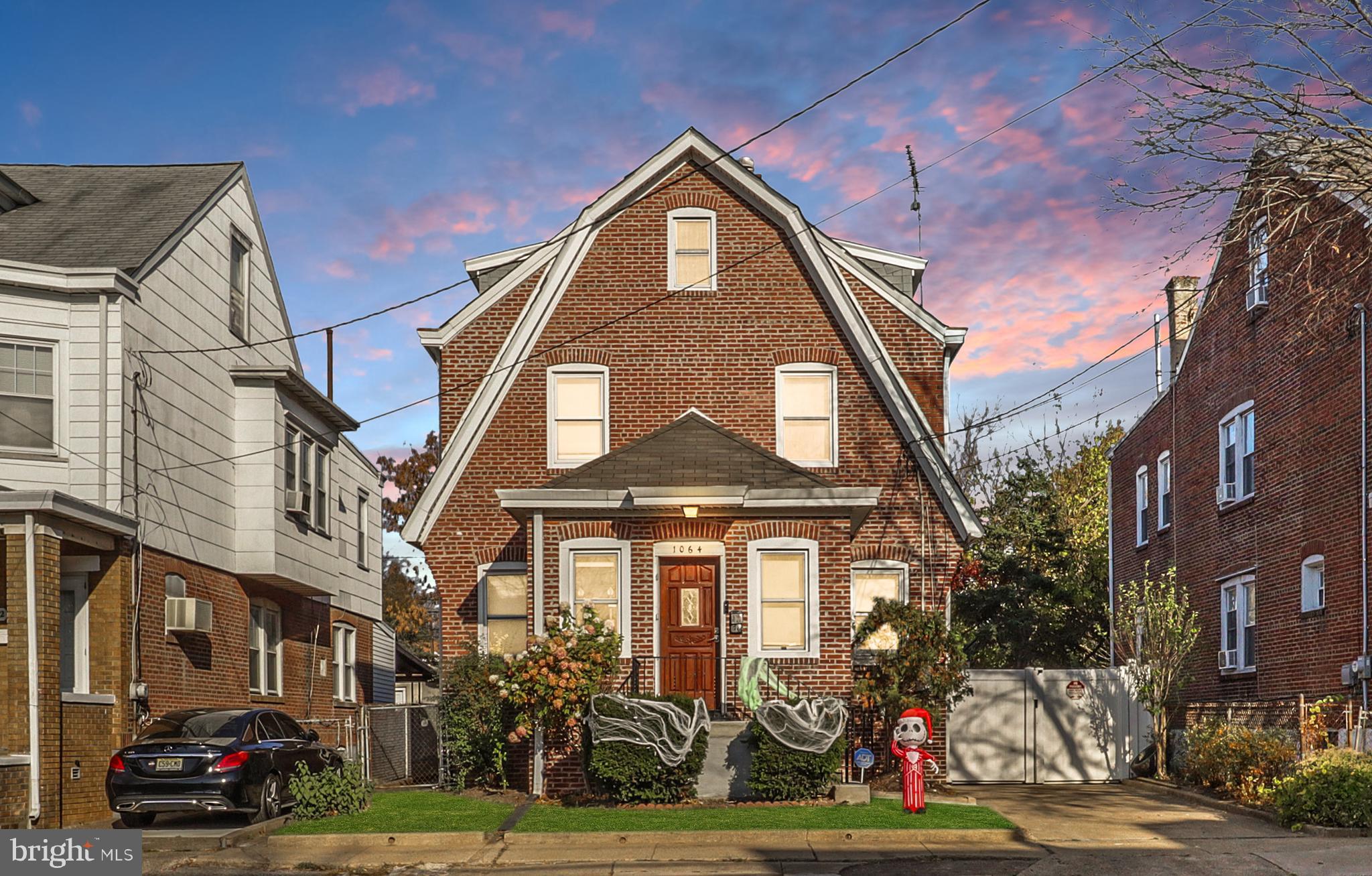 front view of a brick house with a yard