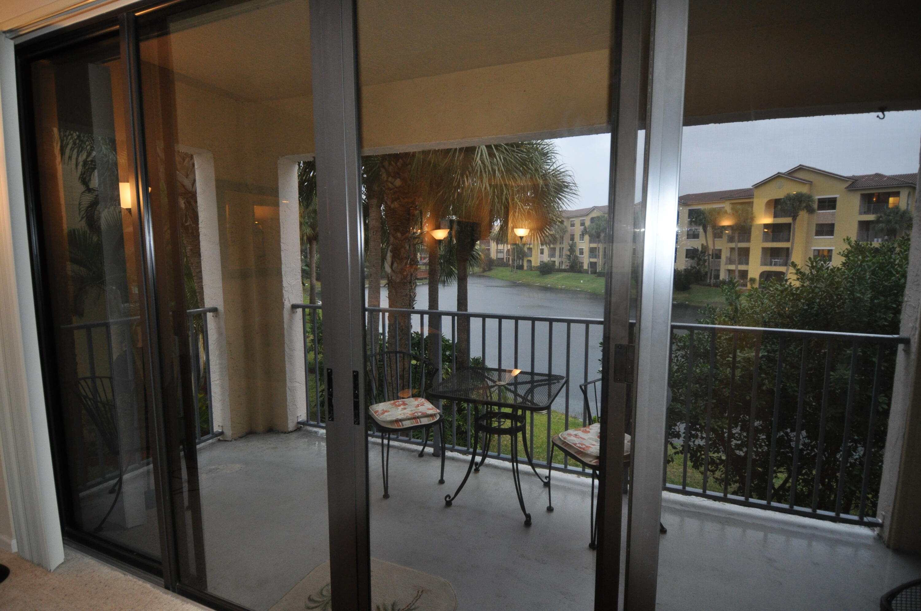 a balcony with chairs and a potted plant on th table