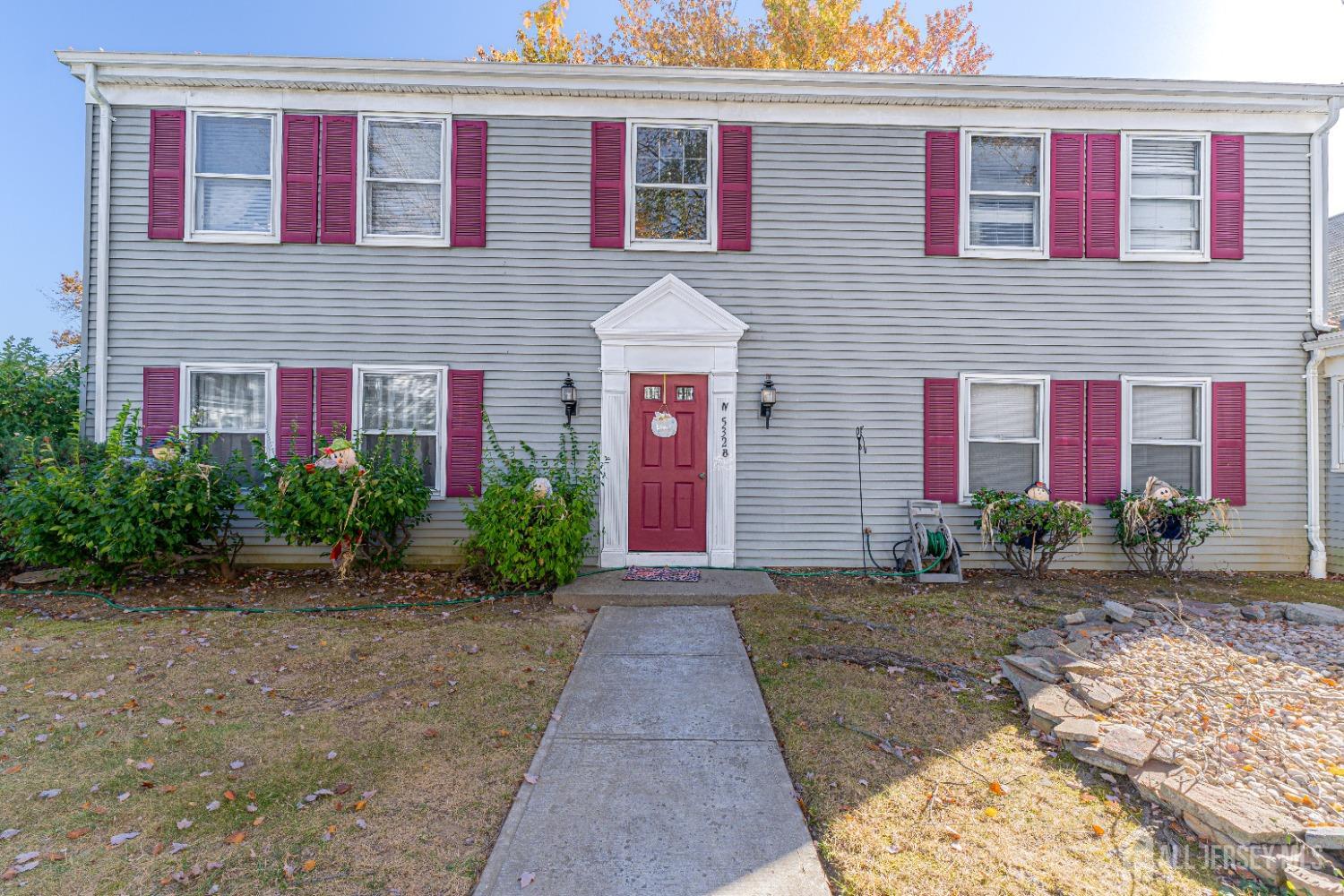 a front view of a house with yard and parking