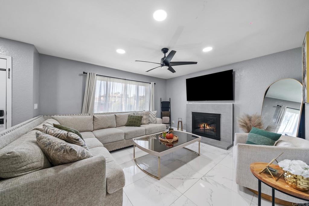 a living room with furniture a fireplace and a flat screen tv