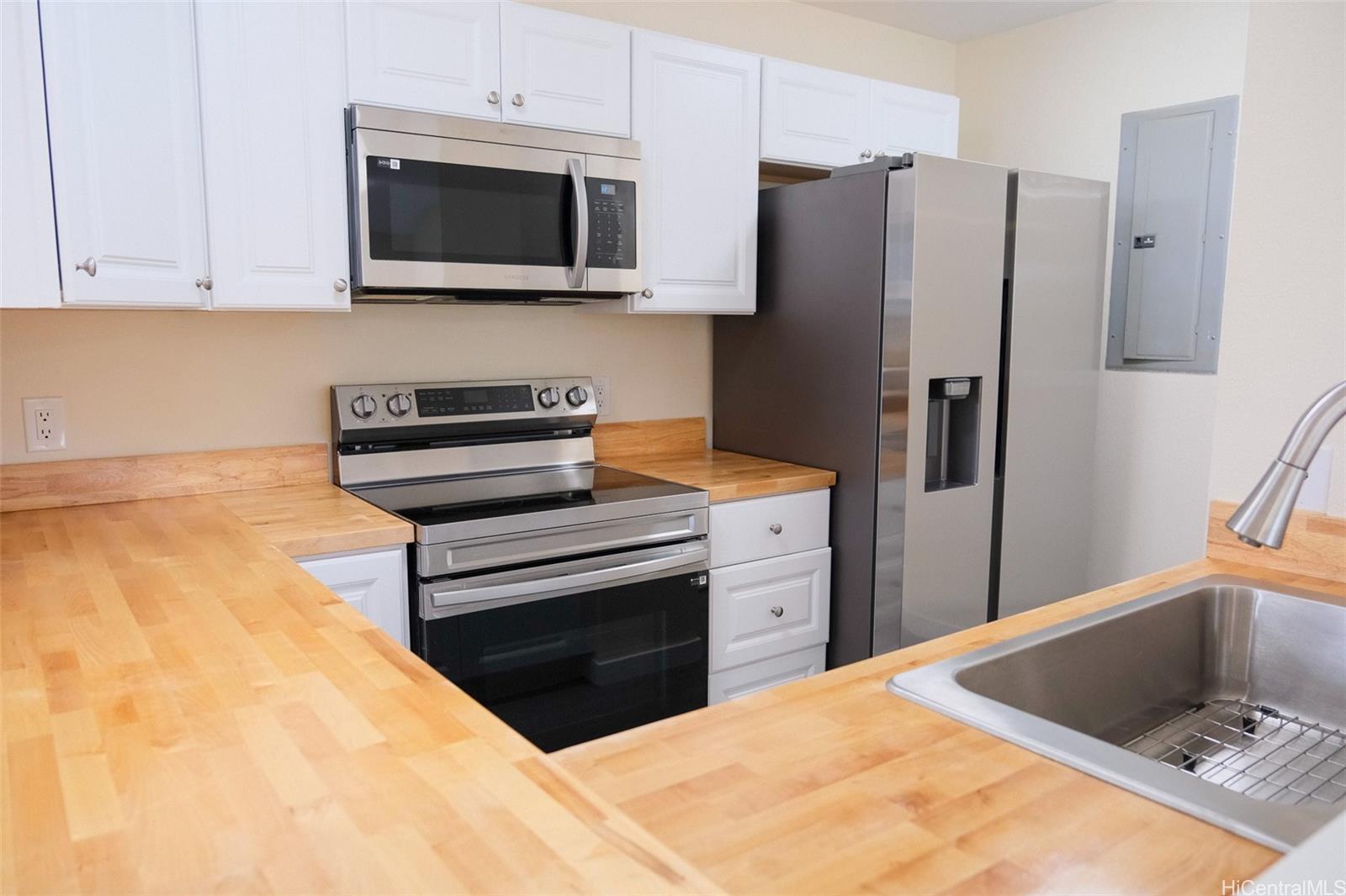 a kitchen with stainless steel appliances granite countertop a refrigerator and a stove top oven