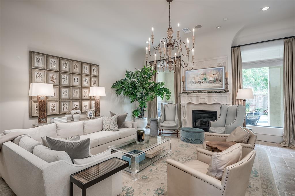 a living room with furniture a chandelier and a fireplace