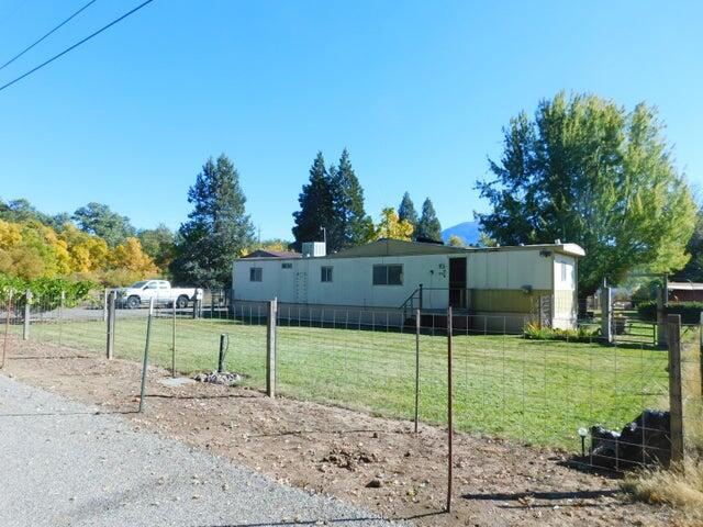 a view of a house with a yard and road