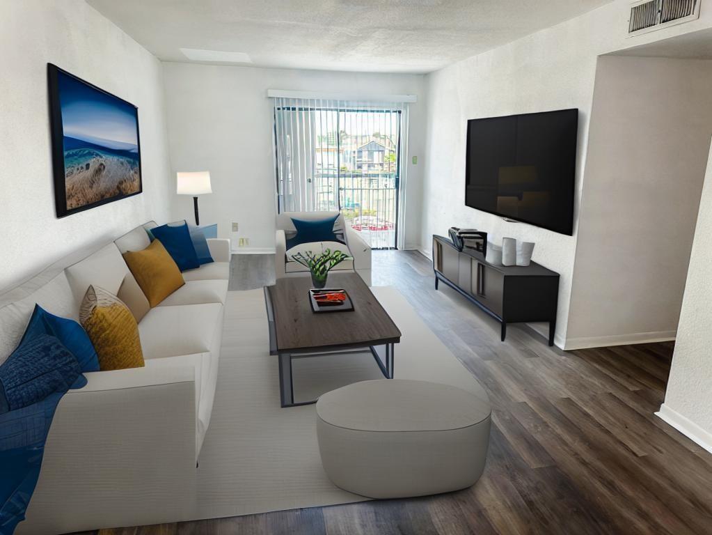 a living room with furniture a flat screen tv and a window