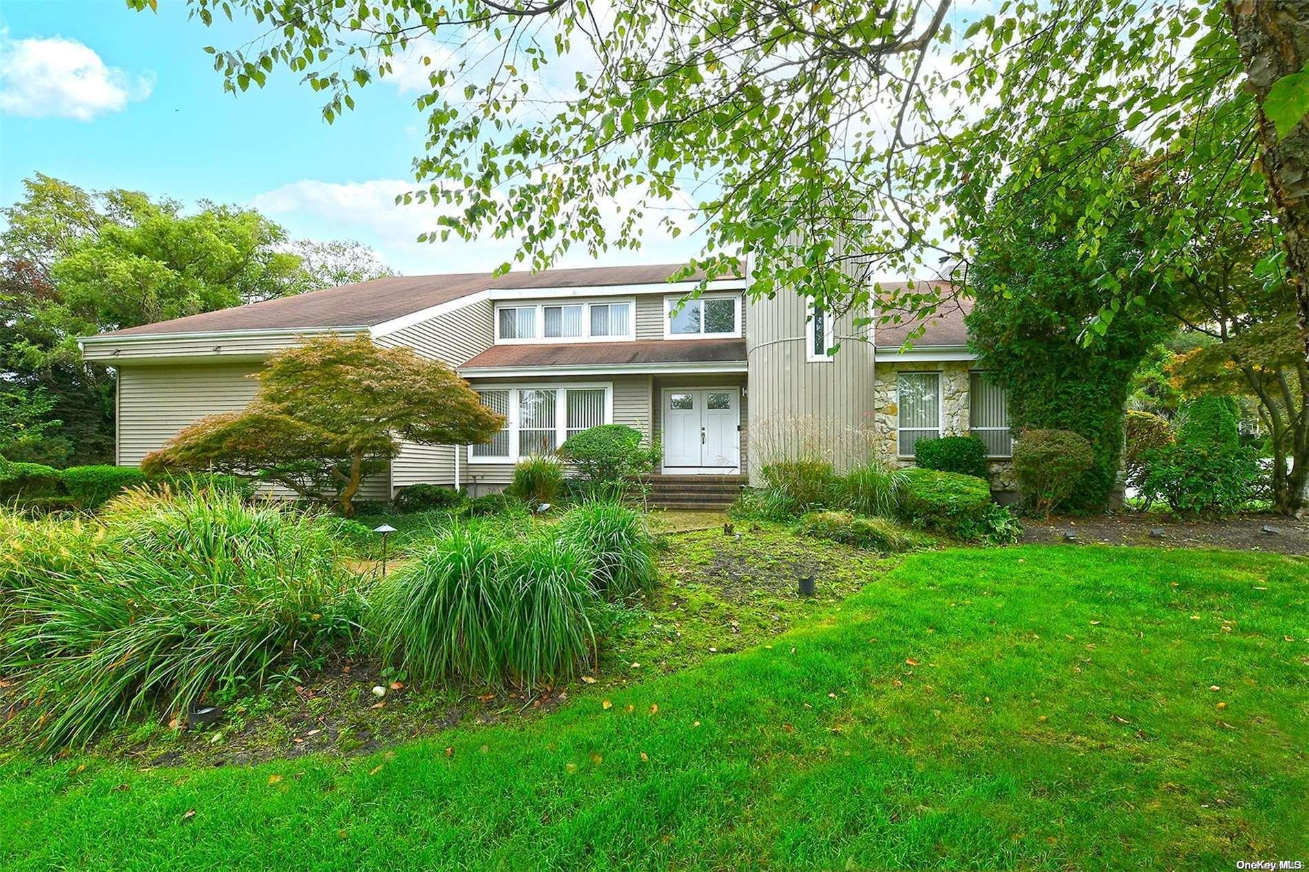 a front view of a house with a tree