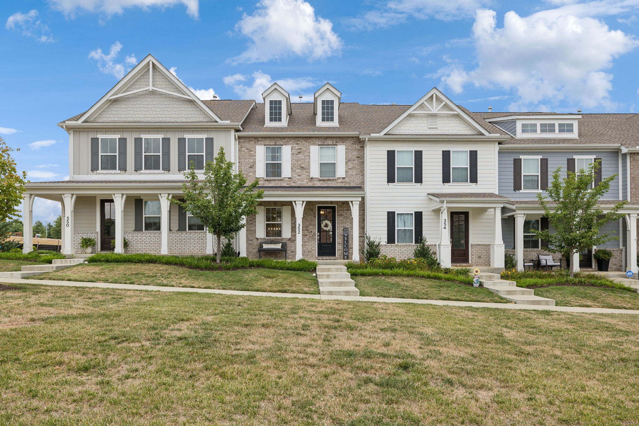 a front view of a residential apartment building with a yard