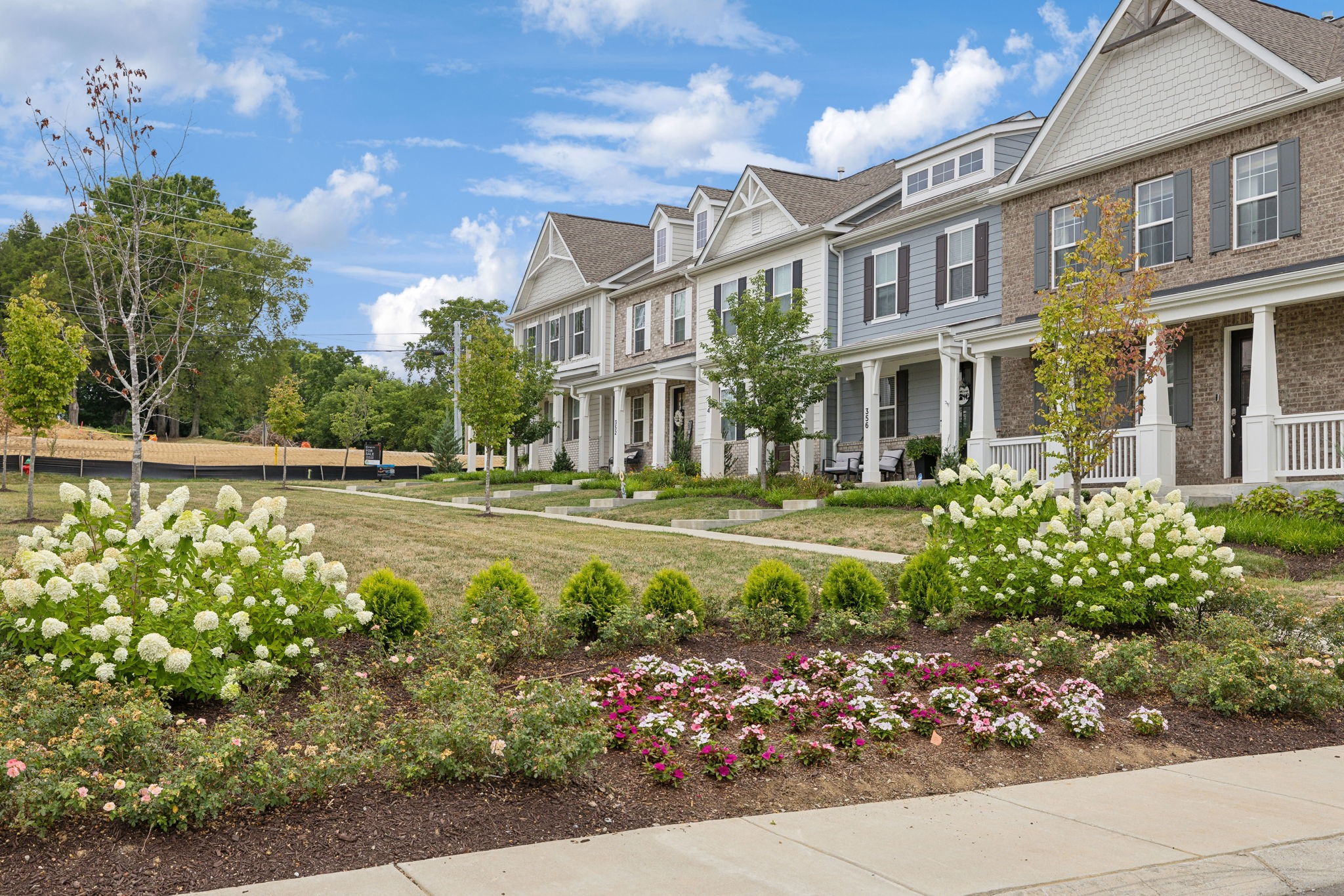 a front view of a multi story residential apartment building with a yard