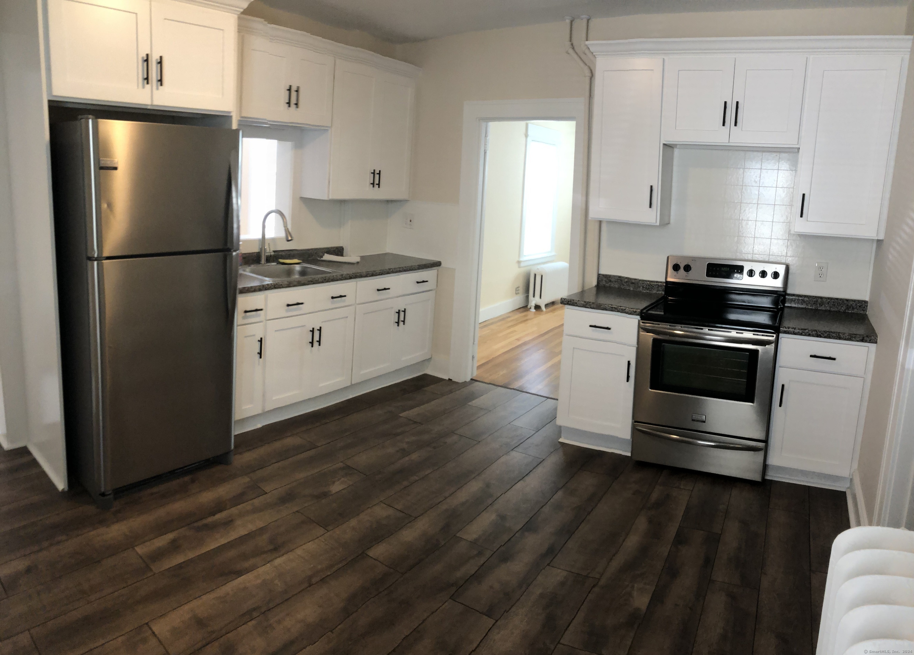 a kitchen with a refrigerator stove and white cabinets