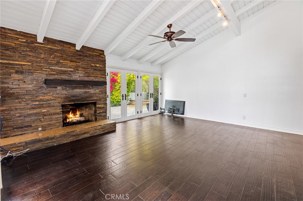 a view of empty room with fireplace and wooden floor