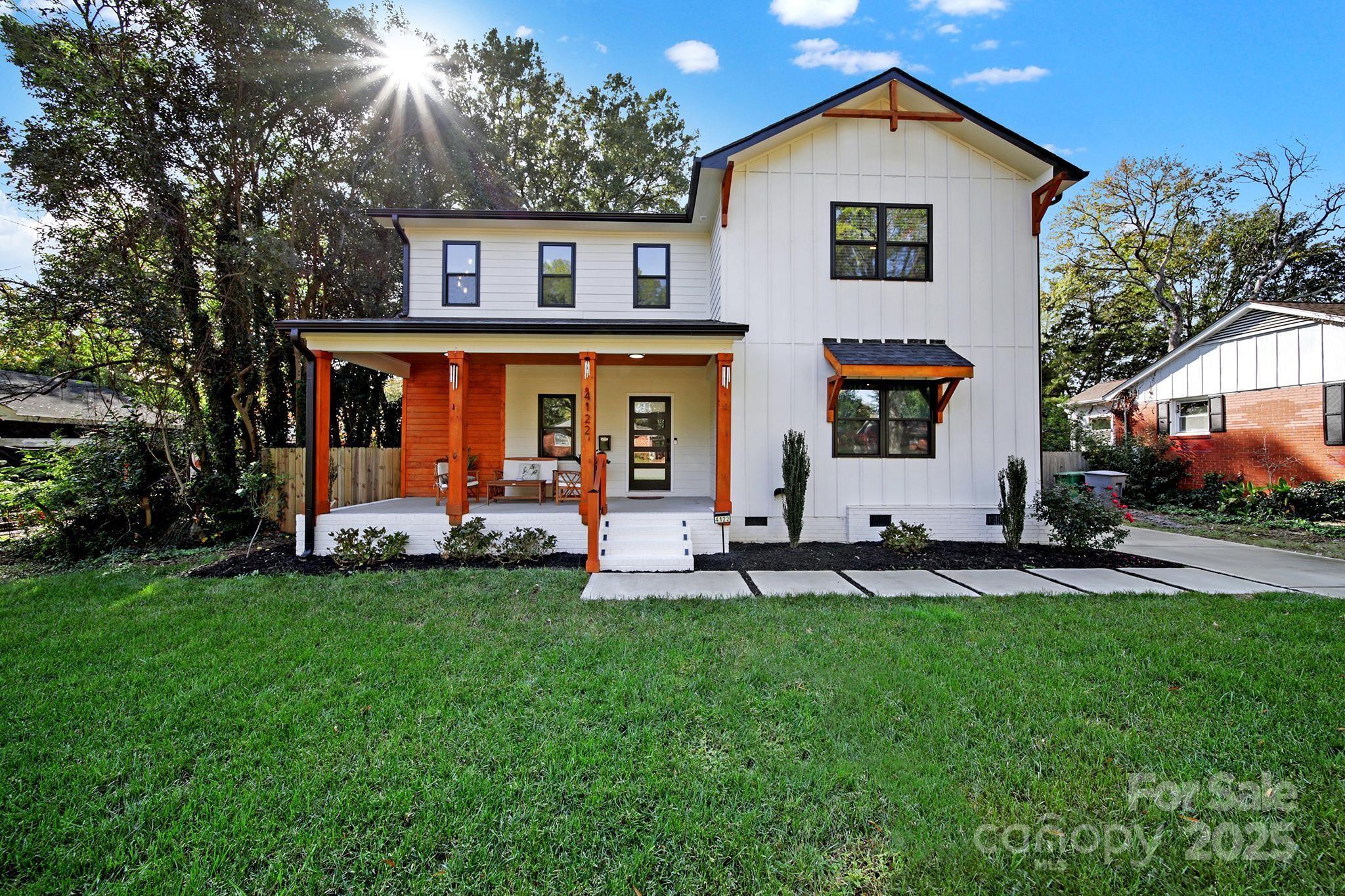 a front view of a house with a yard and trees